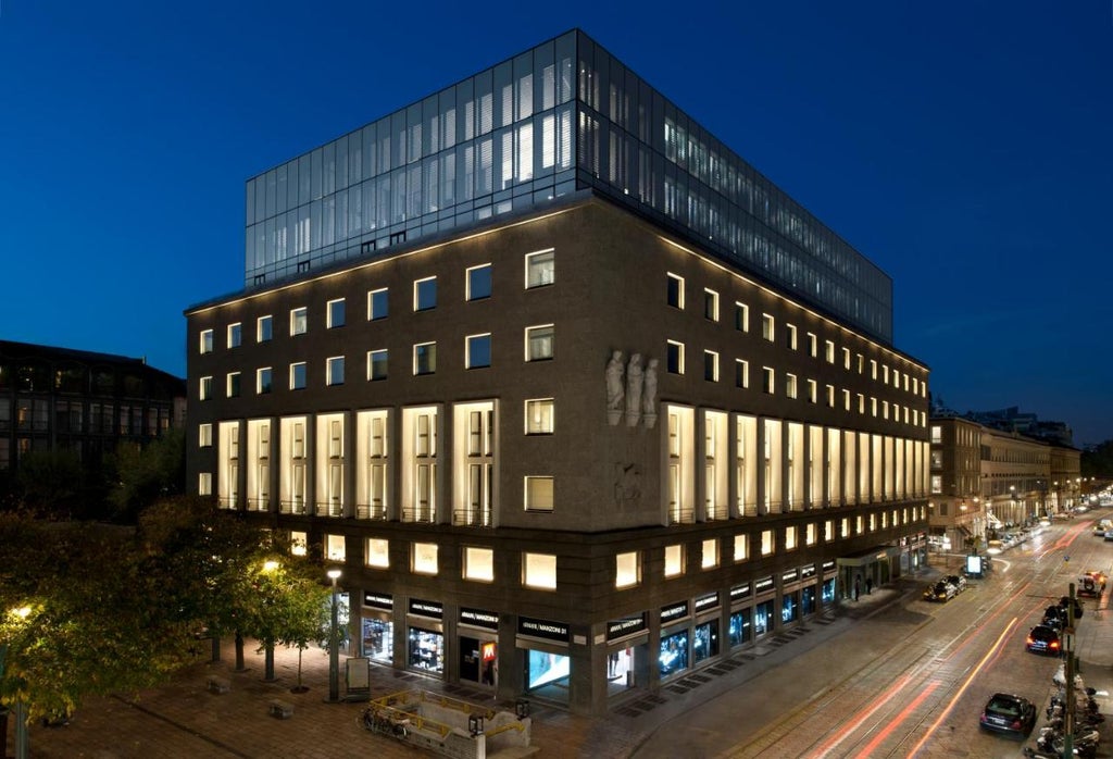 Luxurious modern hotel building in Milan's fashion district with sleek glass facade and sophisticated minimalist design