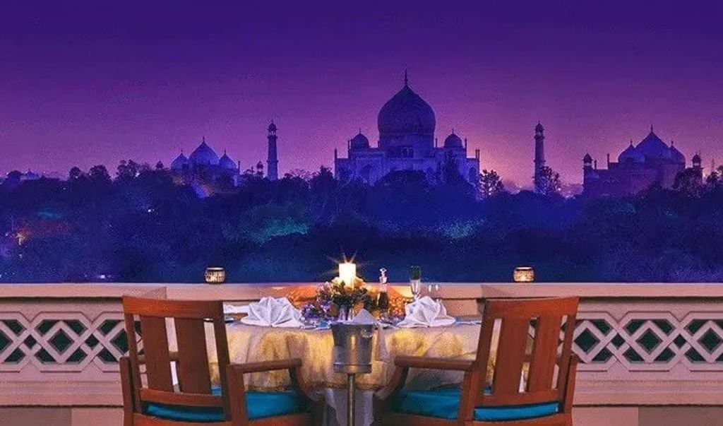 Luxurious pool terrace at Oberoi Amarvilas with Taj Mahal vista, featuring ornate Mughal architecture, manicured gardens and palm trees