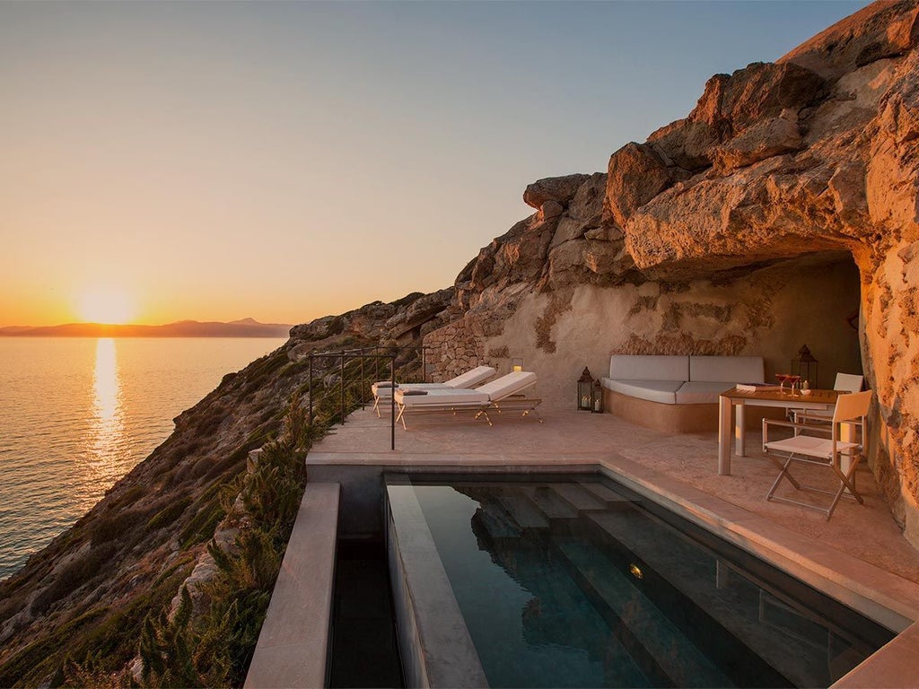 Historic fortress-turned-luxury hotel Cap Rocat perched on Mallorca's cliffs, featuring stone walls and Mediterranean Sea views at sunset