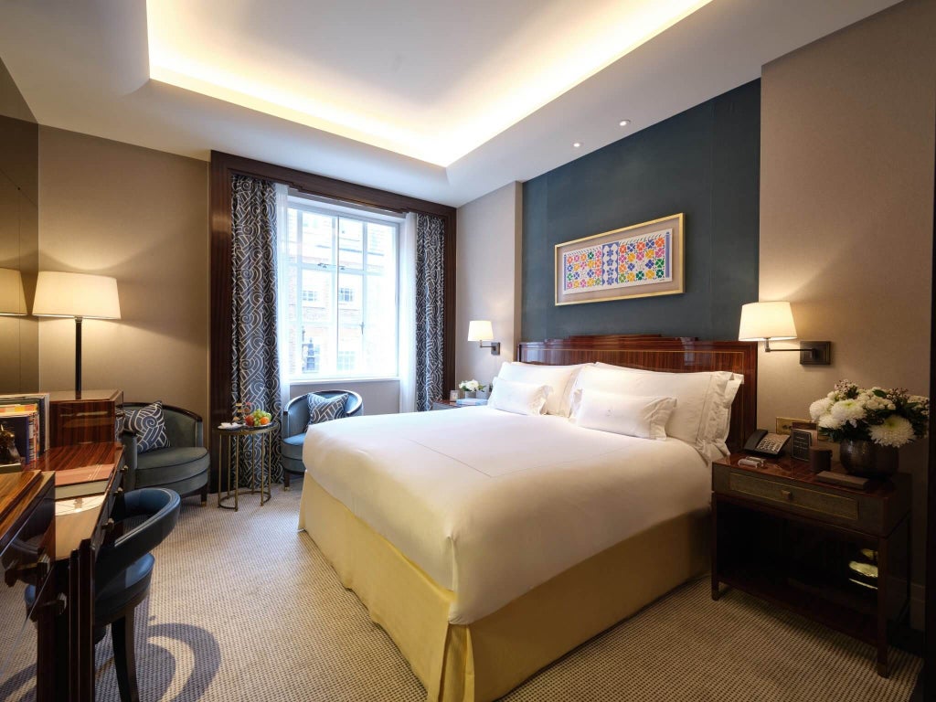 Elegant classic hotel room at The Scenset Mayfair featuring plush white bedding, soft neutral tones, and refined British design with refined artwork.