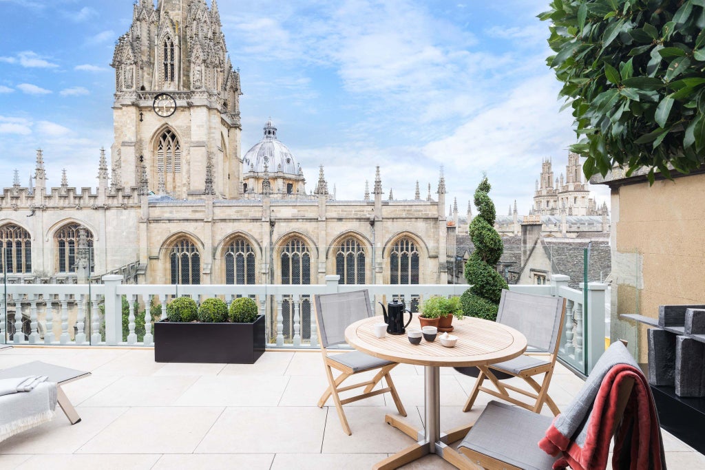 Elegant heritage hotel room with panoramic city view, classic wooden furnishings, large windows, and refined British architectural details in United Kingdom