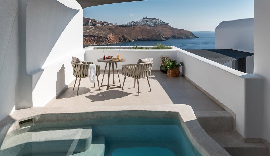 Elegant white-washed Cycladic suites overlooking azure Aegean waters, with minimalist architecture and private balconies at luxurious scenset retreat