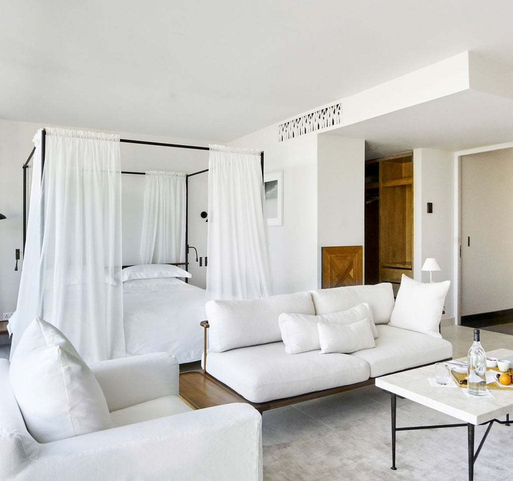 Elegant luxury suite with floor-to-ceiling windows, modern minimalist furnishings, freestanding bathtub and stunning Provençal countryside views