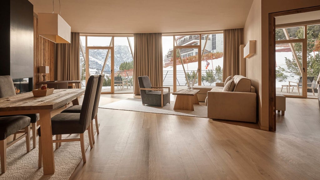 Modern Alpine chalet suite features floor-to-ceiling windows, sleek wood paneling, designer furnishings, and panoramic Dolomite mountain views