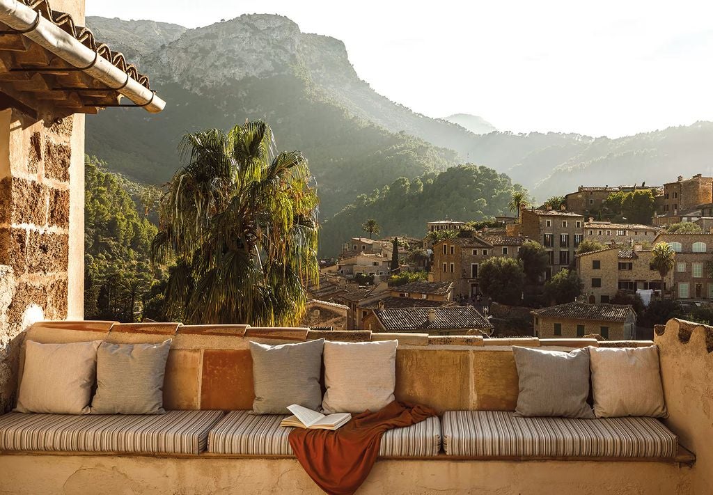 Elegant tower suite with whitewashed walls, terracotta floors, exposed wooden beams, and a luxurious balcony overlooking Mallorca's mountains