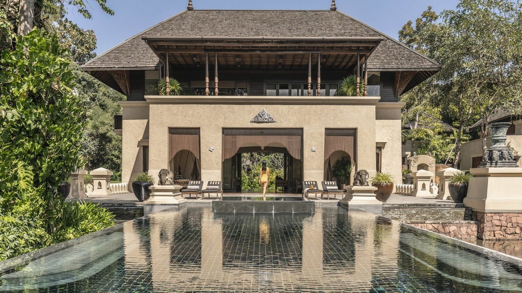 Luxurious infinity pool overlooking lush green rice terraces at Four Seasons Chiang Mai, with traditional Thai pavilions and palm trees