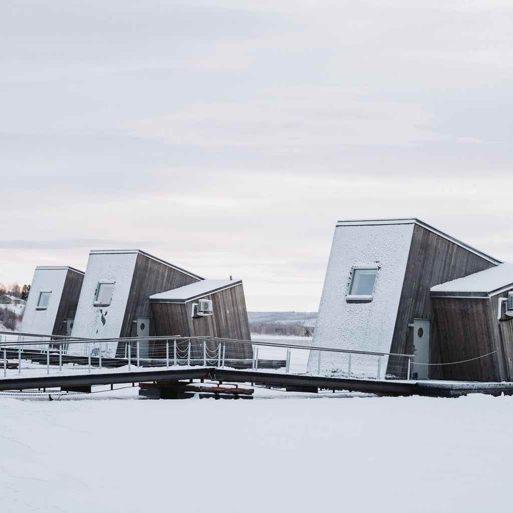 Floating minimalist wooden hotel circular structure surrounded by snow-covered pine trees in Arctic landscape, Sweden's unique winter hospitality design