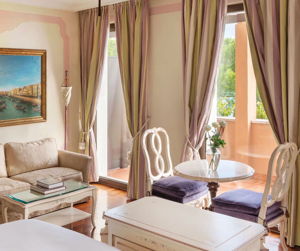 Elegant hotel room with lagoon-view balcony, featuring silk drapes, antique furnishings, marble bathroom and Venetian design details