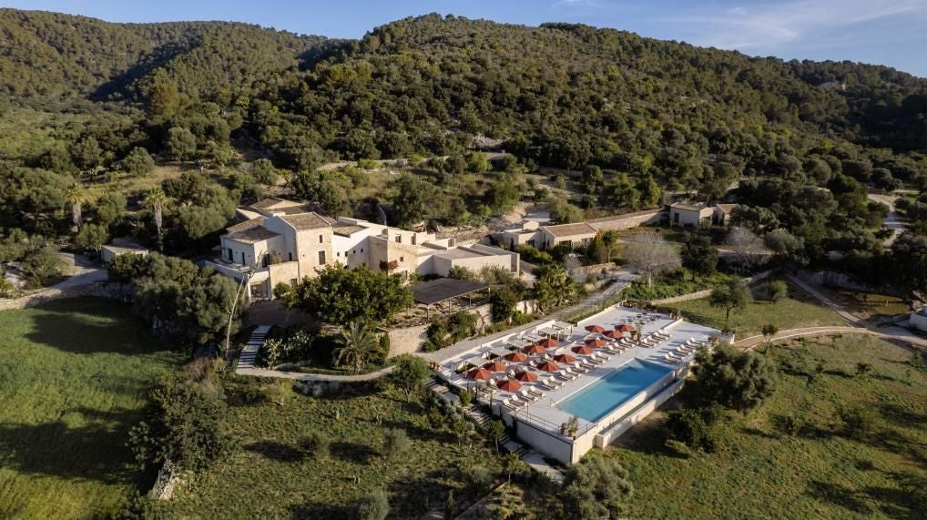 Luxurious boutique hotel nestled in Mallorca's scenic landscape, featuring modern Mediterranean architecture with elegant white walls and inviting poolside area