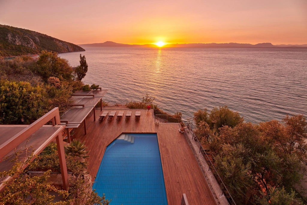 Elegant stone-built Mediterranean villa with terracotta roof nestled in a lush Greek landscape, showcasing timeless architectural charm and serene surroundings.