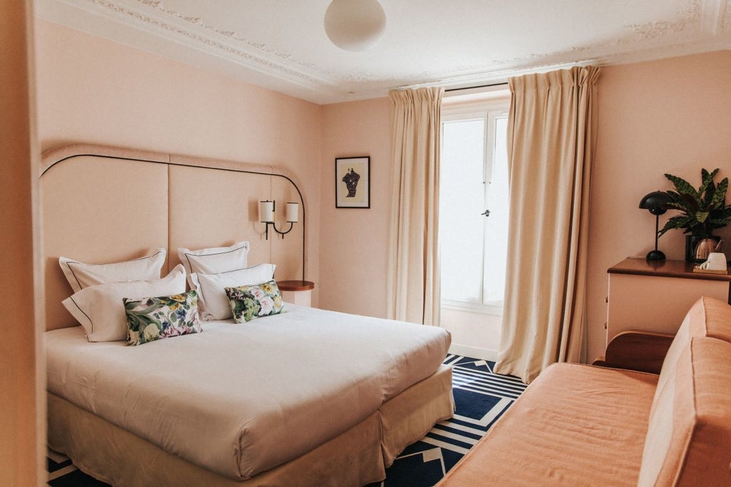 Elegant French hotel room with soft pastel walls, plush white linens, vintage wooden furniture, and warm ambient lighting creating a charming, intimate atmosphere