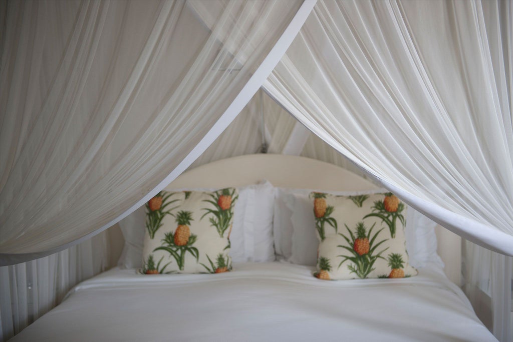 Luxurious green-themed hotel suite in Brazil with elegant turquoise decor, plush bedding, and sophisticated coastal-inspired tropical design elements