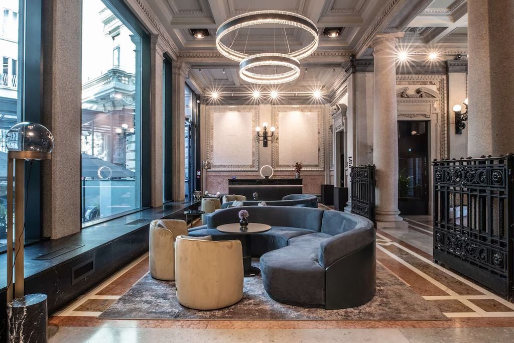 Elegant historic hotel façade in Milan with ornate Renaissance architecture, arched windows and classic stone columns adorning white walls