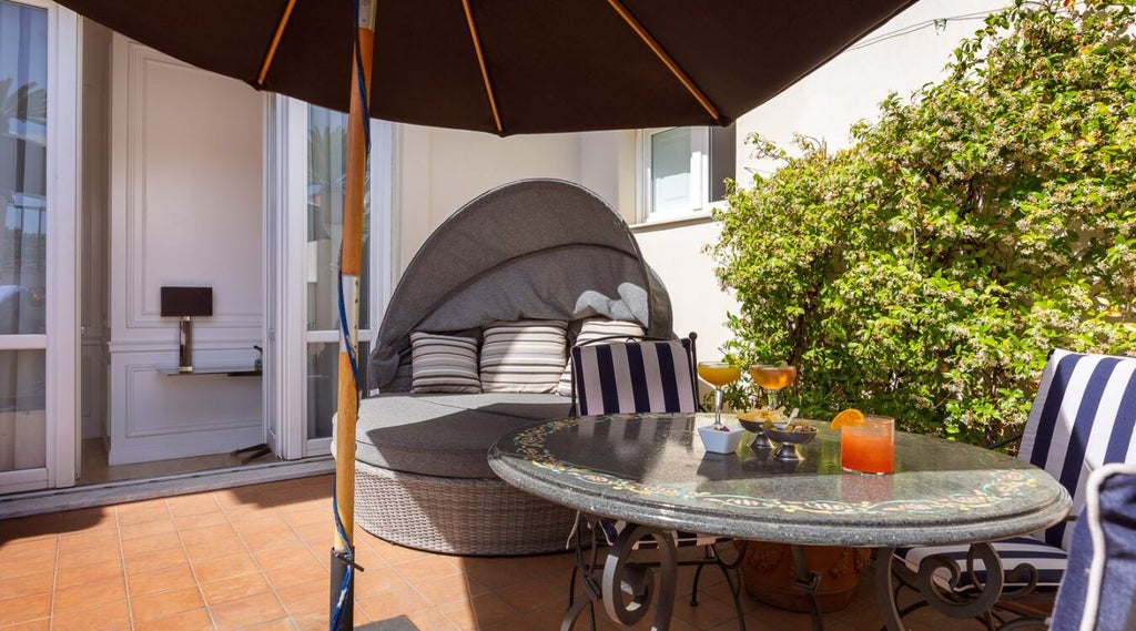 Elegant executive suite at Palazzo Dama, featuring refined white marble, plush king bed, and panoramic windows overlooking Italian architectural splendor