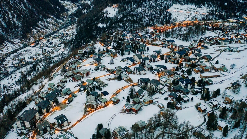 Luxurious alpine hotel nestled in Swiss mountains, with modern chalet-style architecture, snow-capped peaks, and elegant wooden exterior against pristine landscape