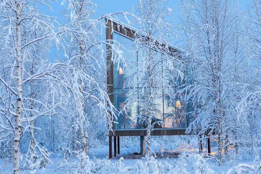 Rustic wooden family room with panoramic windows, minimalist Scandinavian design, natural light illuminating warm timber interiors at Arctic Bath hotel