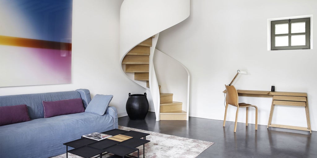 Elegant minimalist hotel room at Château de la Resle, featuring white walls, modern artwork, and contemporary furnishings in a serene French countryside setting