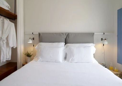 Luxurious Grecian villa bedroom with white-washed walls, traditional archways, elegant wooden furniture, and a panoramic view of scenic vineyards