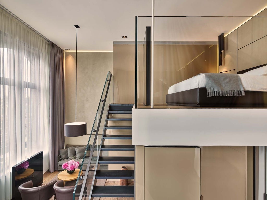 Luxurious Junior Suite at Conservatorium Hotel, featuring modern design, elegant neutral tones, plush bedding, and expansive Amsterdam cityscape view