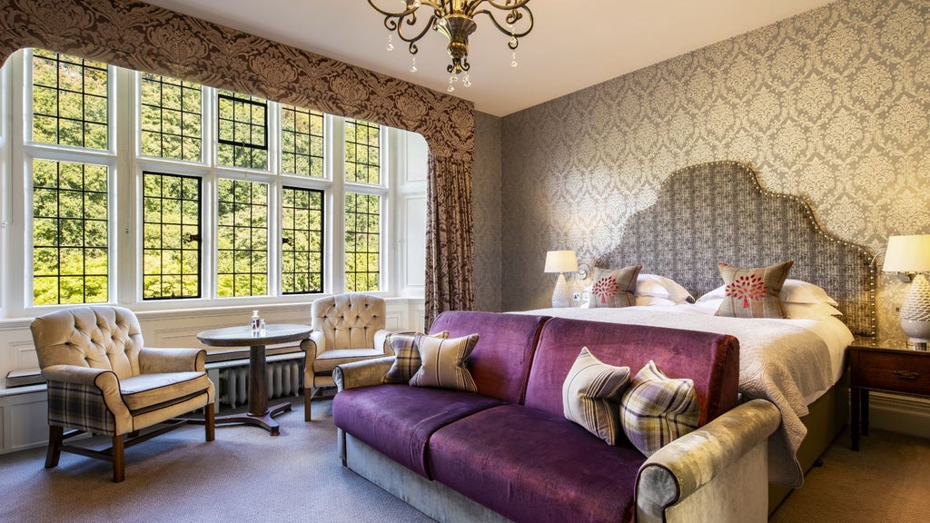 Elegant junior state room at Bovey Castle Hotel and Spa, featuring plush furnishings, rich wood accents, and classic British countryside charm with large windows