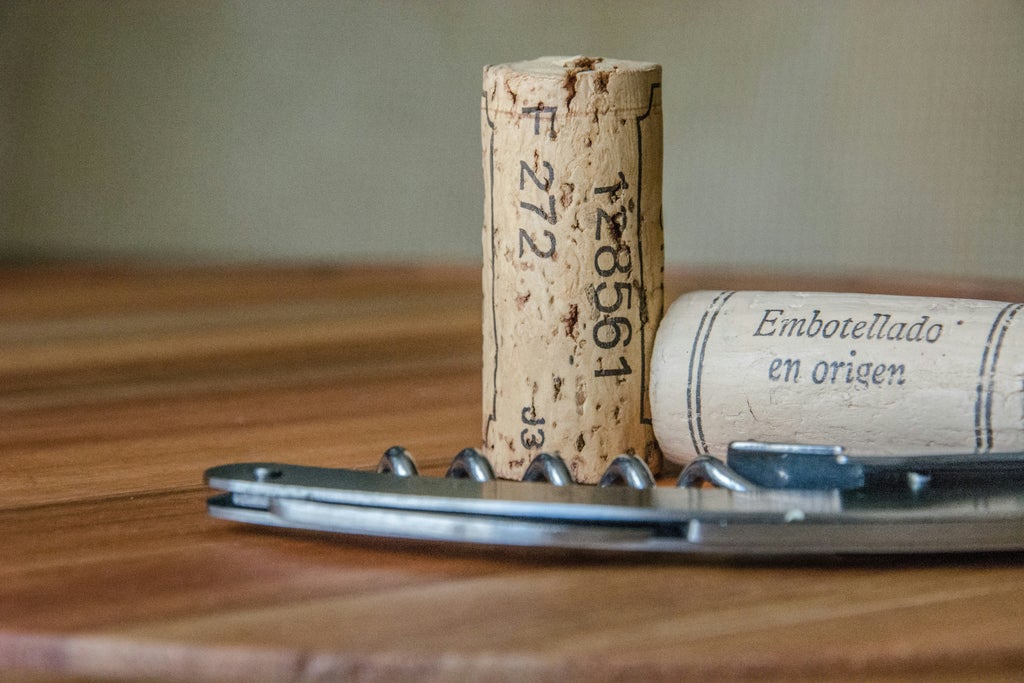 Elegant vineyard landscape with rolling hills, sun-drenched vines, and a rustic table set for a sophisticated wine tasting experience in Provence, France