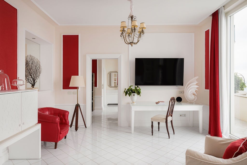 Luxurious coral-toned suite with panoramic coastal view, elegant marble bathroom, and refined Mediterranean decor at seaside hotel in Sorrento