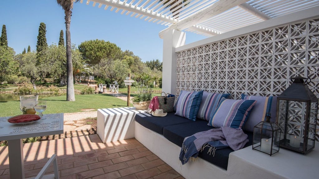 Whitewashed villa with terracotta roofs nestled in Algarve landscape, featuring elegant pool, lush gardens, and traditional Portuguese architectural charm