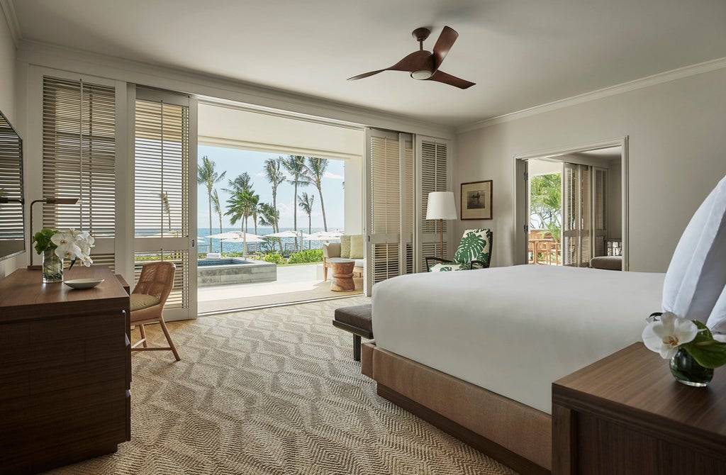 Elegant ocean-view pool with infinity edge at Four Seasons Hawaii, overlooking pristine beach and Pacific waters at sunset