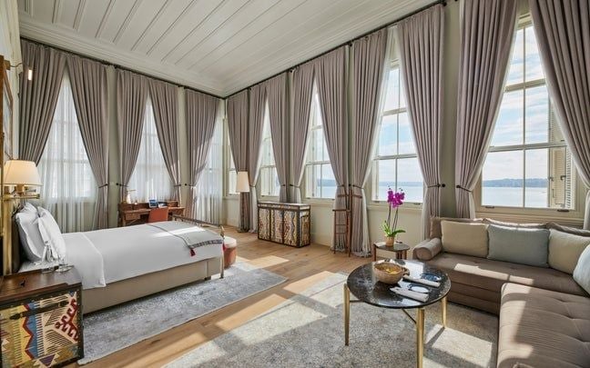 Elegant Bosphorus Junior Suite with Ottoman-inspired decor, plush white bedding, and expansive water views at luxury Six Senses hotel in Istanbul