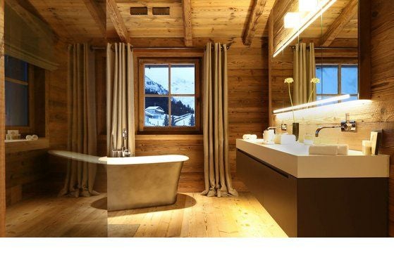 Luxurious alpine chalet bedroom with panoramic mountain views, plush white bedding, and rustic wooden accents in elegant minimalist design