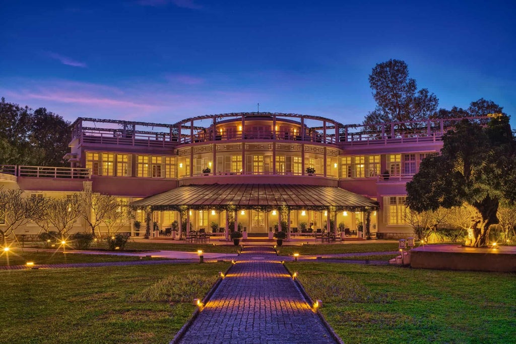 Luxurious colonial-style hotel with elegant white facade, lush tropical gardens, and French architectural influences in historic Hue, Vietnam