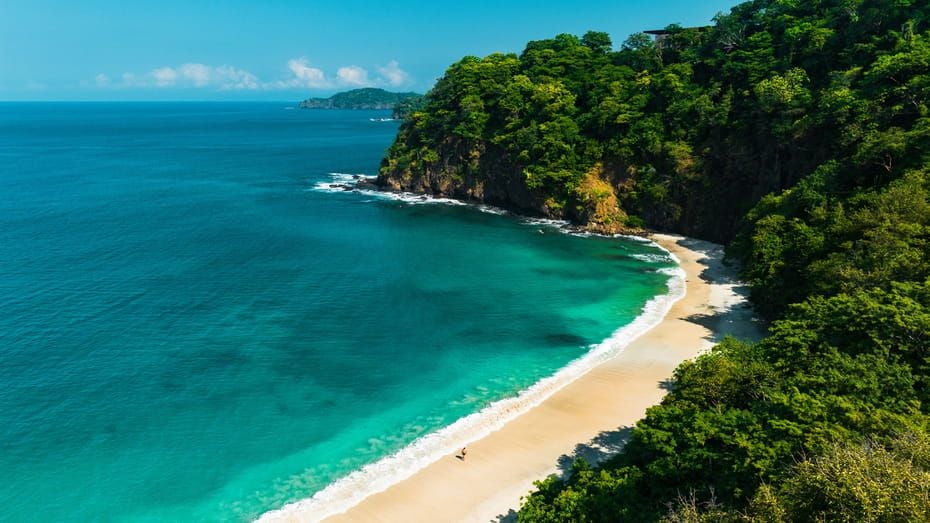 Luxurious Four Seasons Papagayo resort perched on Costa Rican hillside, infinity pool overlooking Pacific Ocean and lush tropical forest