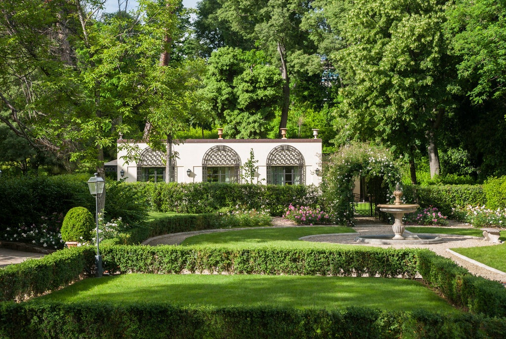 Renaissance-style Four Seasons hotel in Florence with ornate facade, manicured gardens, grand marble fountains and sweeping archways