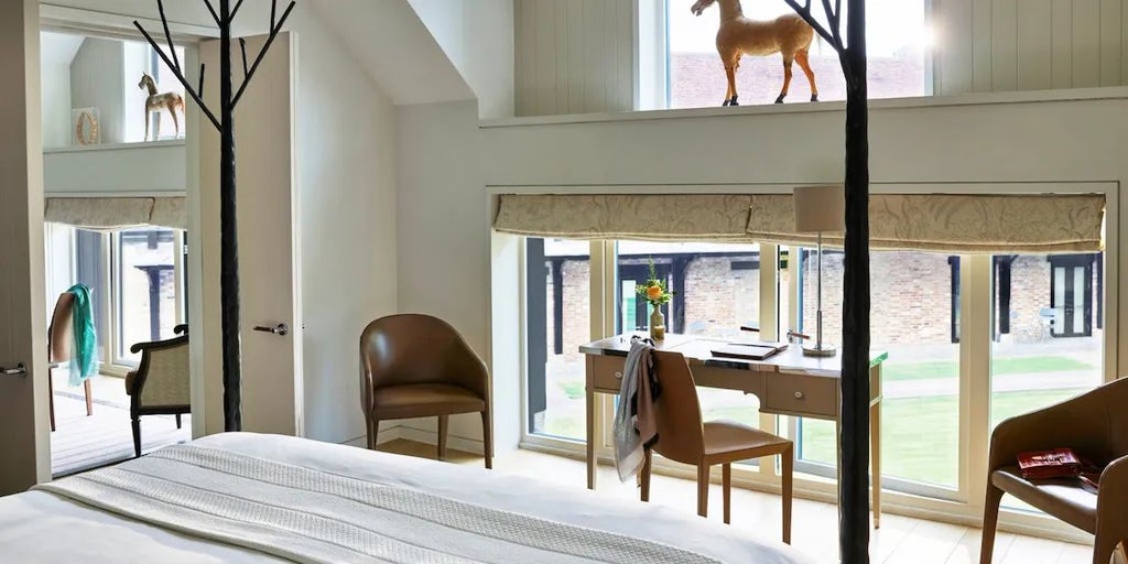 Elegant stable-inspired luxury suite with rich wooden furnishings, plush seating, and refined equestrian decor at a high-end countryside hotel retreat