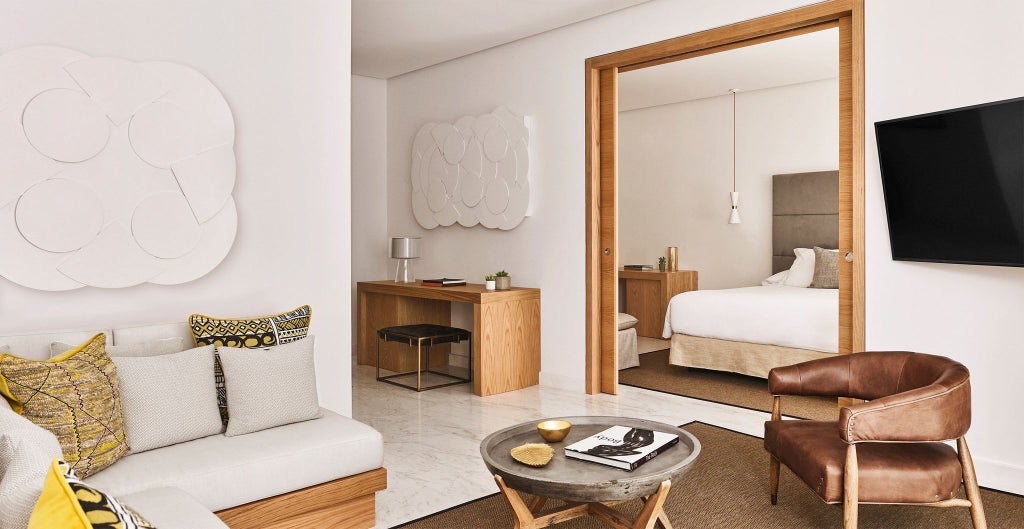 Luxurious Nobu Hotel Marbella Deluxe Room with crisp white bedding, modern minimalist design, and panoramic coastal view through large windows