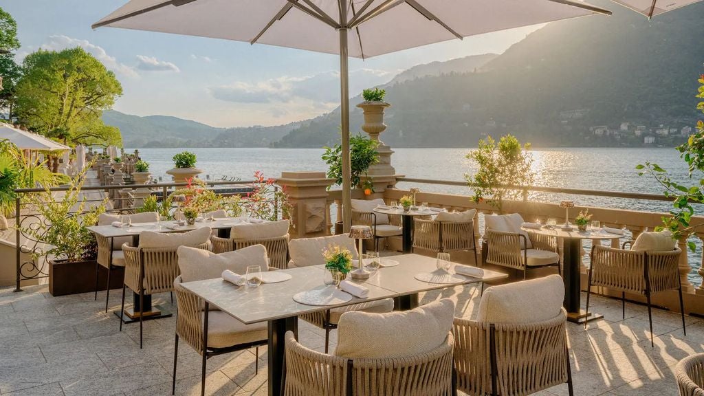 Elegant Italian villa-hotel overlooking Lake Como, featuring stone balconies, terraced gardens, and panoramic mountain views at sunset