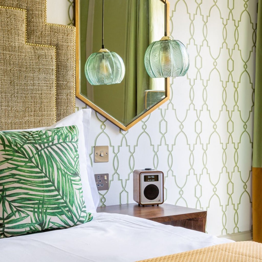 Elegant master deluxe hotel room with plush cream bedding, rich wood furnishings, and soft ambient lighting at The Queensberry Hotel in the United Kingdom.