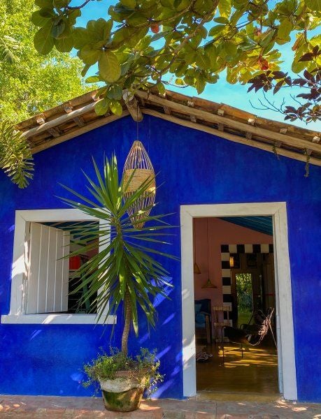 Rustic wooden interior of luxurious Casa Das Artes suite at UXUA Casa Hotel, featuring handcrafted furniture and warm Brazilian design elements in Trancoso