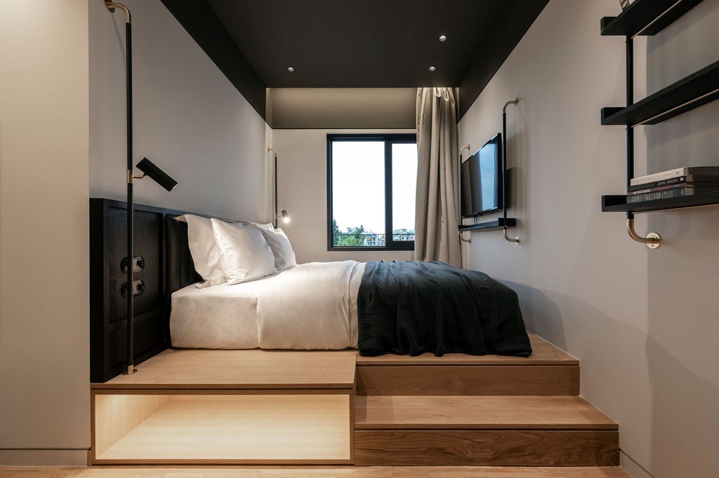 Minimalist hotel room in Athens with sleek gray walls, modern white bed, designer lighting, and large window revealing urban skyline view