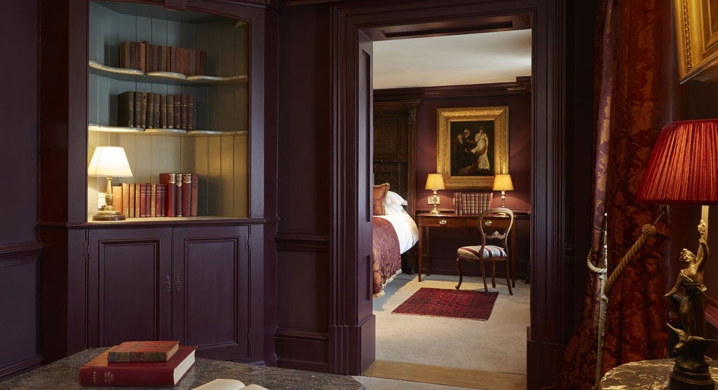 Opulent Georgian-style boutique hotel room with ornate four-poster bed, richly textured walls, and elegant period furnishings in United Kingdom