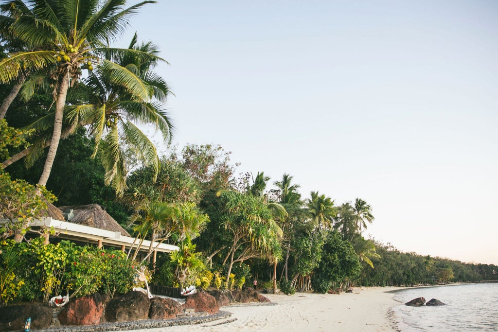 Luxurious overwater villa nestled on Fiji's Turtle Island, with expansive ocean views, private deck, and traditional thatched roof against turquoise waters