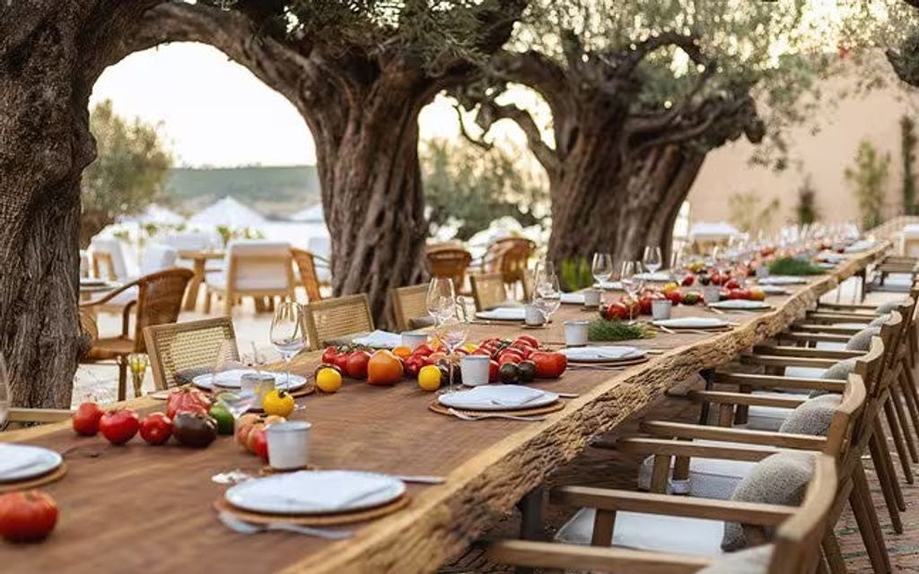 Modern luxury beachfront resort with infinity pool overlooking Mediterranean Sea, white architecture nestled into Ibiza's coastal cliffs