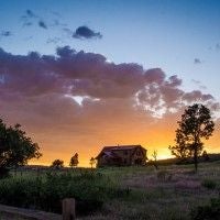 Rustic lodge bedroom with wooden furnishings, plush bedding, and large windows overlooking scenic mountain landscape near national park