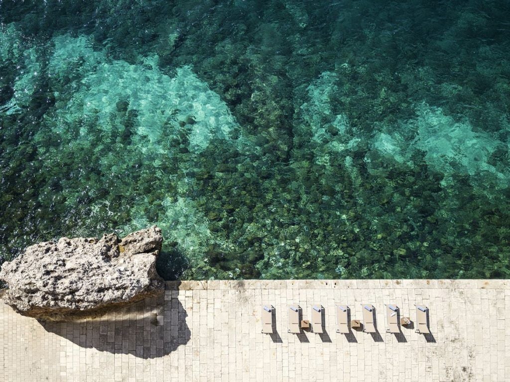 Elegant five-star Hotel Excelsior in Dubrovnik with grand seafront terrace, overlooking the Adriatic Sea and iconic city walls at sunset