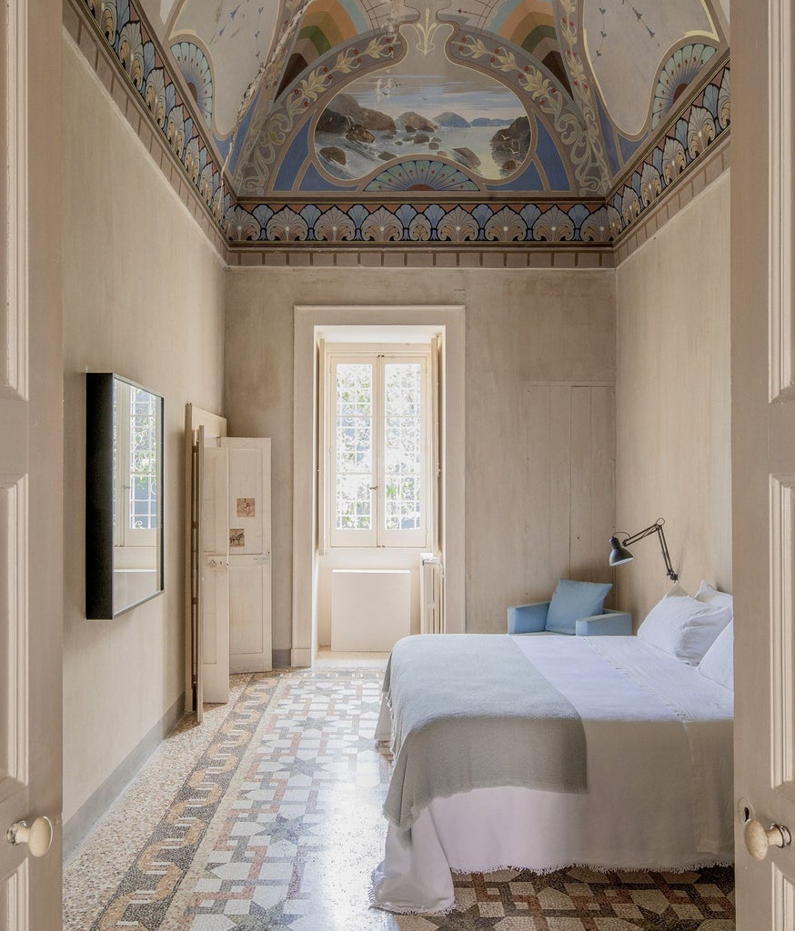 Opulent royal junior suite at Palazzo Daniele with ornate frescoed ceiling, elegant marble floors, and plush four-poster bed in soft neutral tones