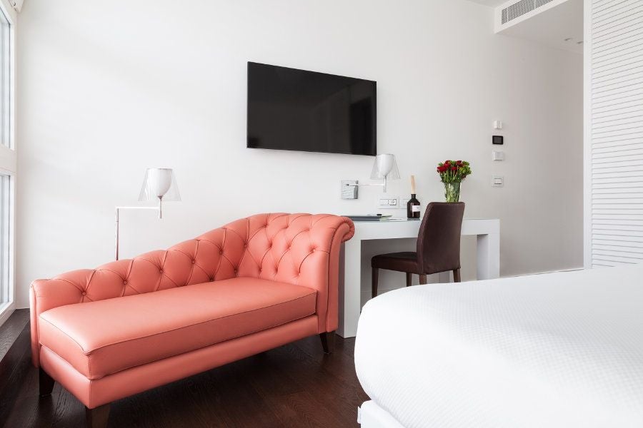 Elegant junior deluxe hotel room with modern design, soft neutral color palette, luxurious furnishings, and subtle perfume-inspired decor in Milan