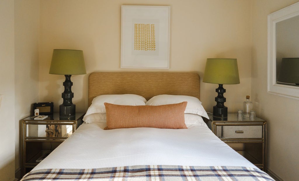 Elegant medium double hotel room with plush white bedding, warm wooden furniture, and soft neutral tones at The Beckford Arms in scenic United Kingdom