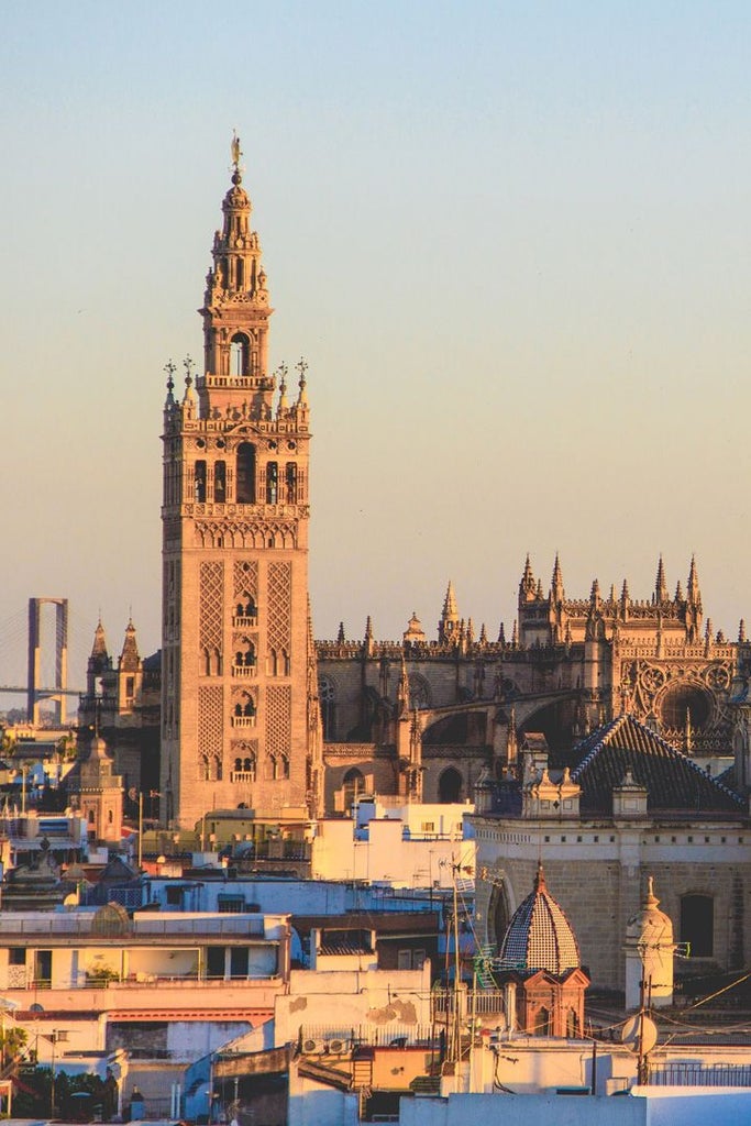 Luxurious rooftop terrace of boutique hotel overlooking Barcelona's Gothic Quarter with sunlit Mediterranean views and elegant poolside seating