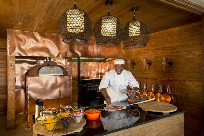 The interactive kitchen at Sandibe invites guests to create their own pizza or burger after a game drive