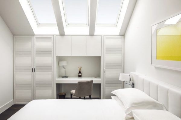 Luxurious Italian hotel room with modern minimalist design, soft neutral tones, elegant furnishings, and subtle perfume-inspired decor in Milan